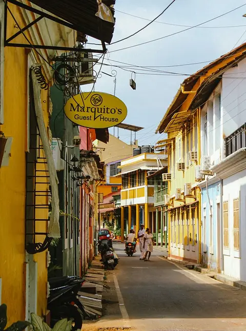 A quiet Panjim street of Portuguese-era houses, scooters parked along the kerb